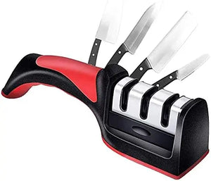 A 4-piece kitchen knife sharpener set with a black and red ergonomic handle, three sharpening slots, and four knives displayed on top, isolated on a white background.