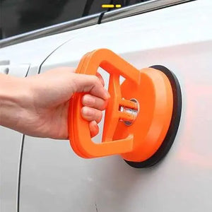 Orange suction cup tool being used on a car door