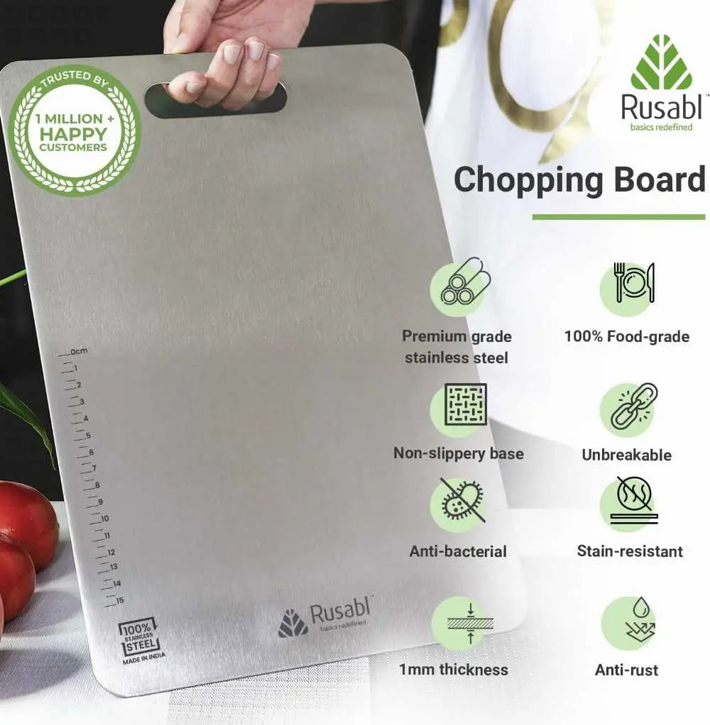A stainless steel cutting board with a built-in handle, shown being held by a hand. The board features measurement markings on one side, a green 'Trusted by 1 Million+ Happy Customers' badge, and a list of product features on the right side, including 'Premium grade stainless steel', 'Non-slippy base', and 'Anti-bacterial'.